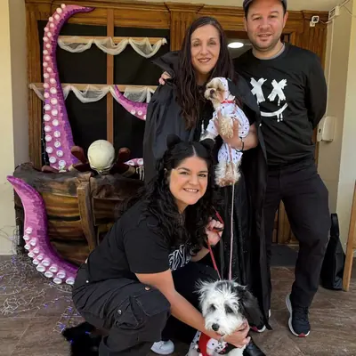 Una familia posa con sus dos perros frente a la decoración pirata.